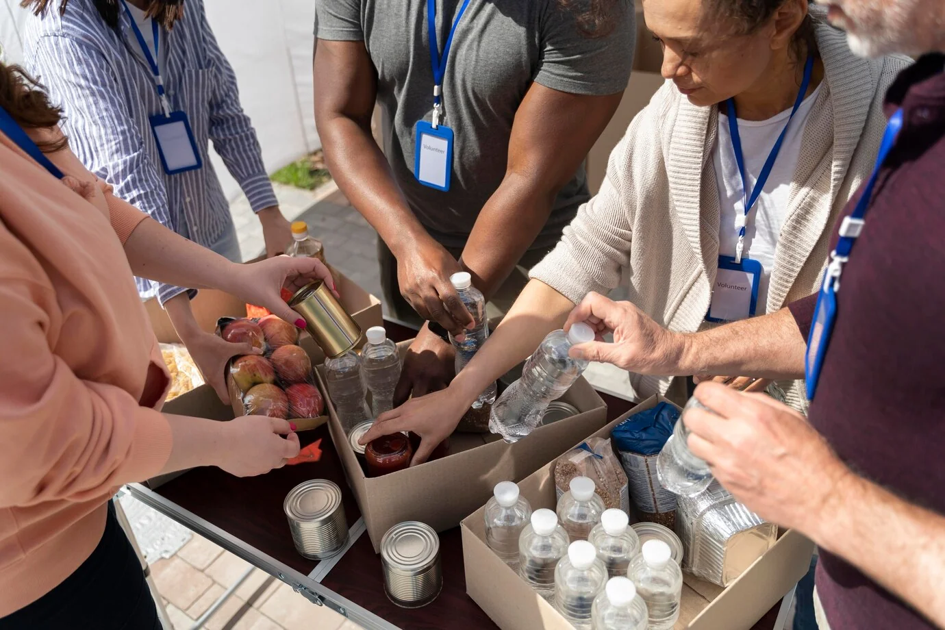 Voluntariado organizando agua y alimentos en cajas de ayuda.